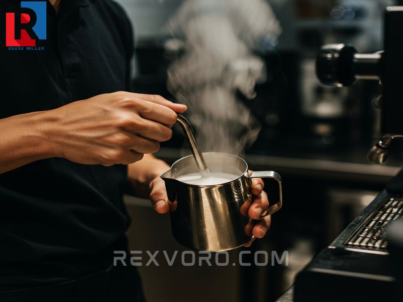 barista-steaming-milk-in-a-steel-pitcher-with-a-steam-wand-creating-a-vortex-for-perfect-microfoam