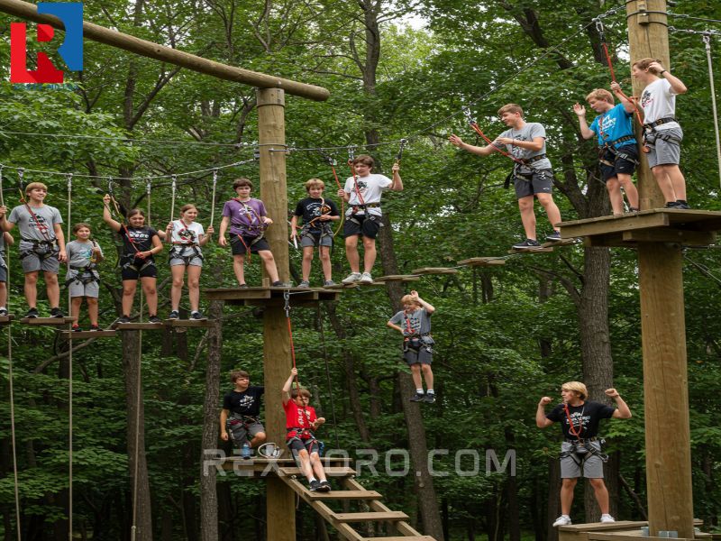 a-group-of-teenage-campers-actively-participating-in-a-high-ropes-challenge-course-cheering-each-other-on-as-one-teen-navigates-a-tricky-obstacle-showcasing-dynamic-sum