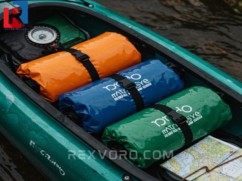 organized-kayak-stern-hatch-with-three-colored-dry-bags-a-map-and-a-compass-for-camping