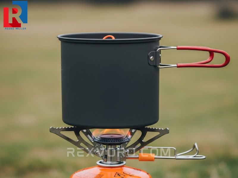 proper-usage-of-a-folding-camping-pot-set-up-on-a-gas-canister-stove-emphasizing-the-need-for-the-flame-to-stay-on-the-metal-base-for-safety