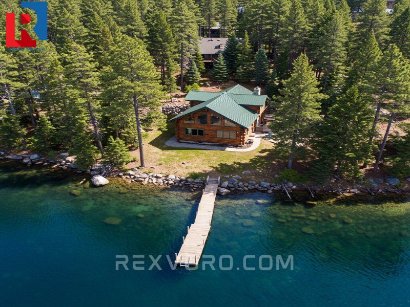 rustic-lake-house-cabin-and-private-dock-nestled-among-pine-trees-on-a-clear-blue-lake
