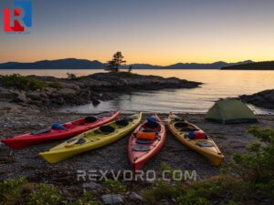 three-colorful-kayaks-and-a-tent-on-a-rocky-island-beach-at-sunset